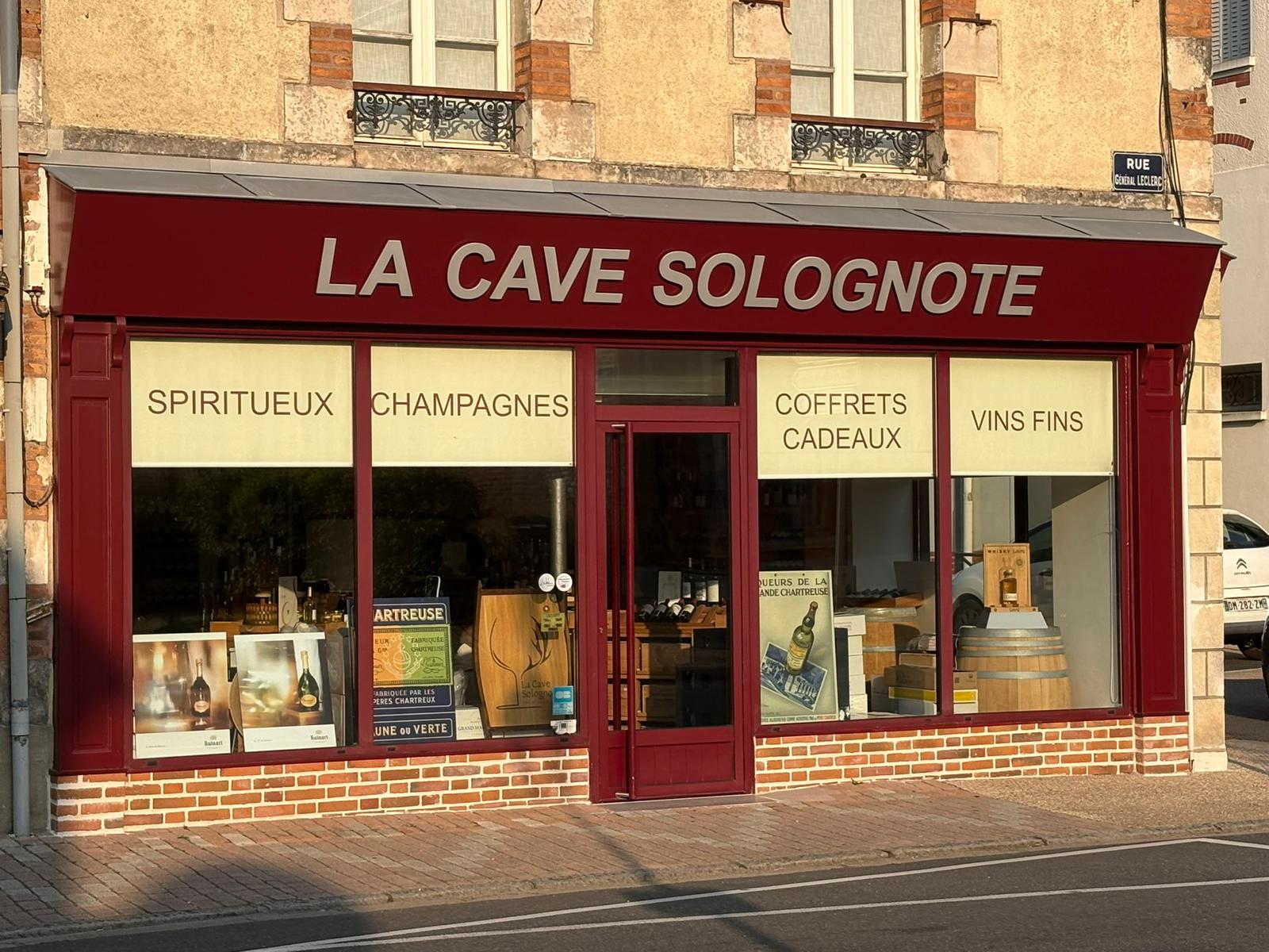 La devanture bordeaux de La Cave Solognote à La Ferté-Saint-Aubin, à la lumière du soir